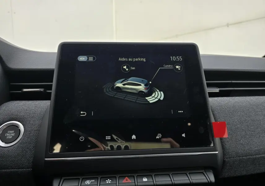 Écran tactile central affichant l'aide au stationnement de la Renault Clio V gris Rafale, vue intérieure avant.
