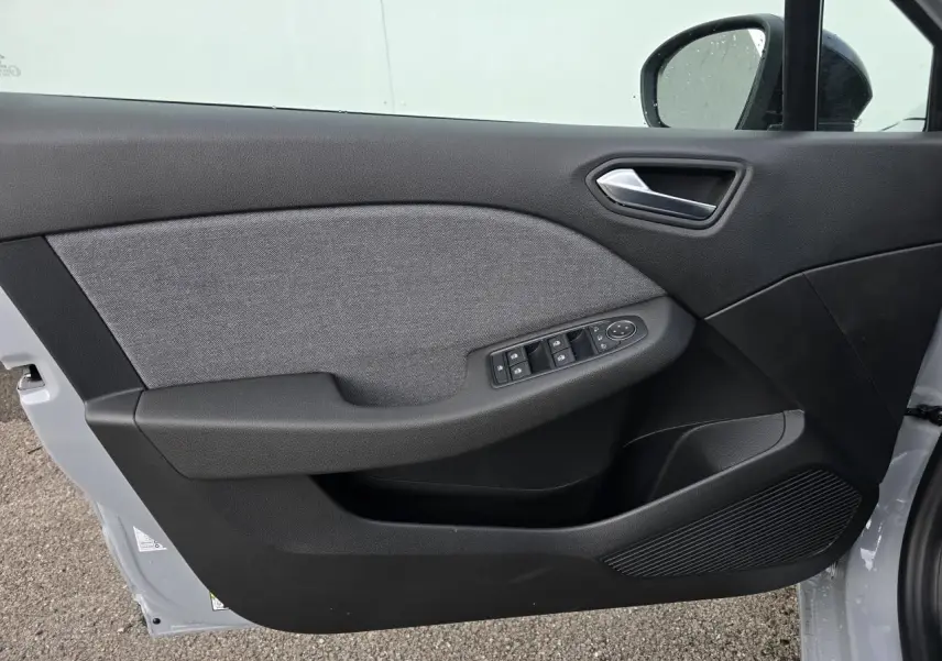 Vue intérieure de la porte avant gauche de la Renault Clio gris Rafale, avec commandes de vitres et poignée argentée.