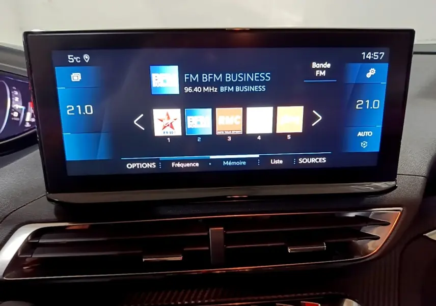 Écran tactile central du tableau de bord du Peugeot 5008 noir, affichant la radio FM BFM Business.