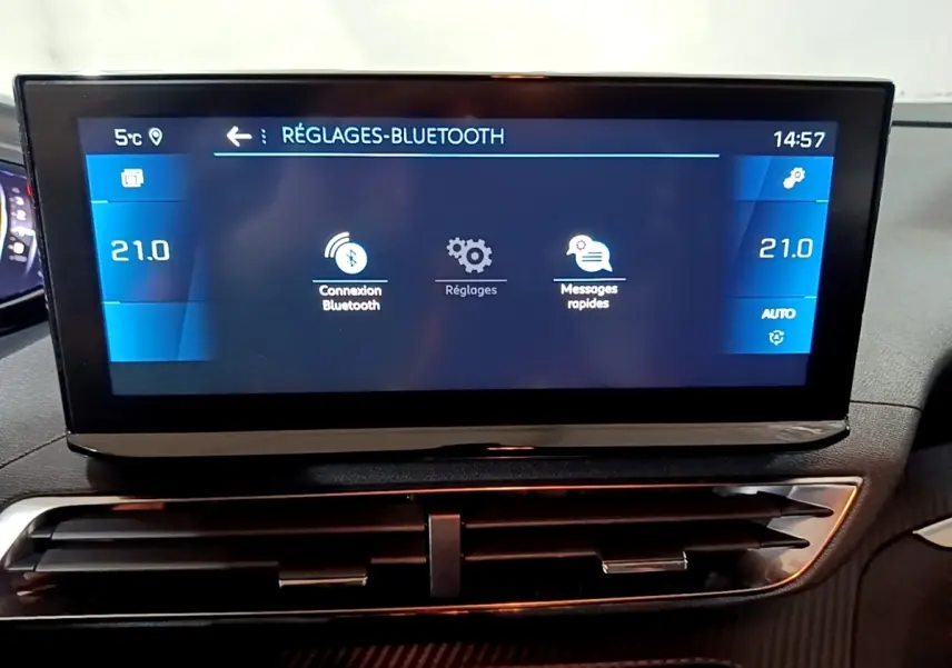 Écran tactile central du tableau de bord du Peugeot 5008 noir, affichant les réglages Bluetooth et la climatisation à 21°C.