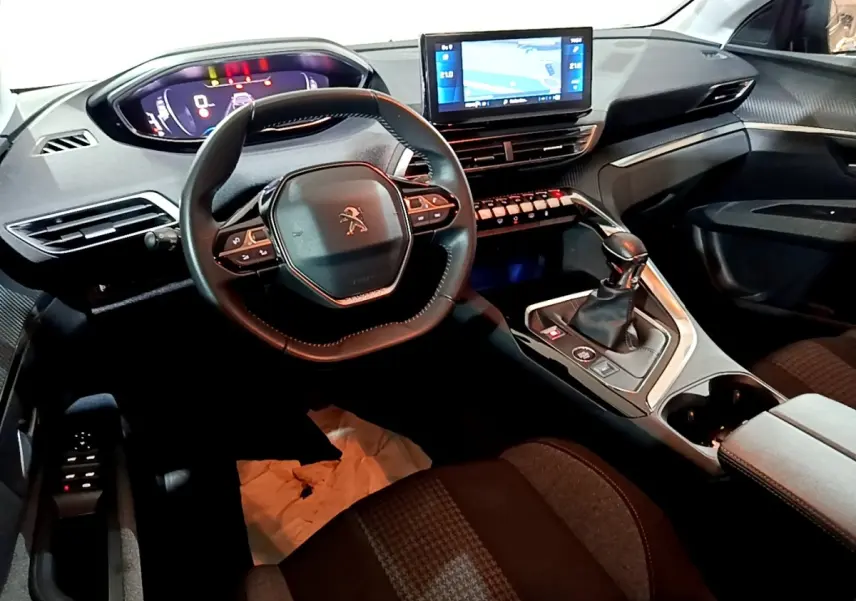 Intérieur noir du Peugeot 5008 PureTech 130, vue du poste de conduite avec volant compact et écran tactile central.