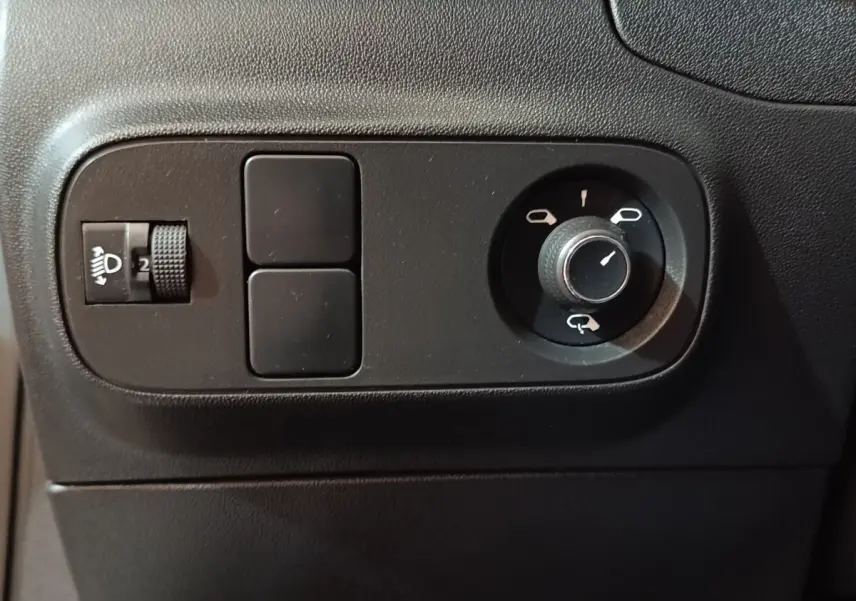 Détail du tableau de bord noir de la Citroën C3 2020, montrant les commandes de réglage des phares et des rétroviseurs.