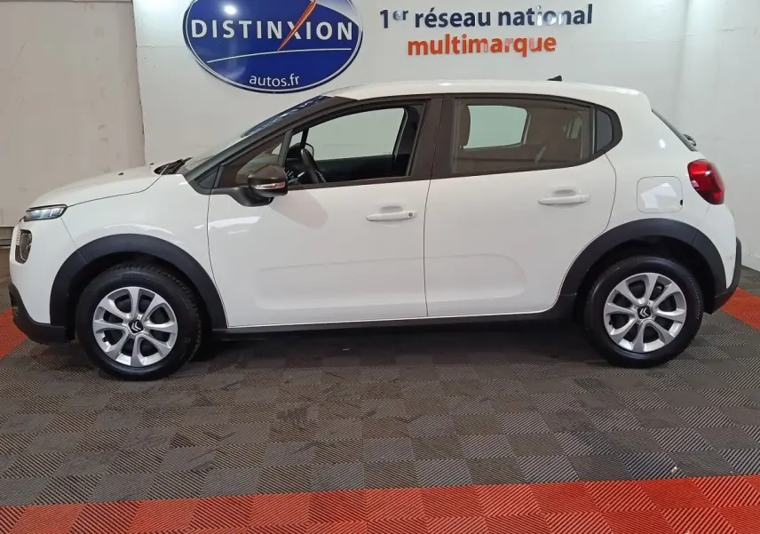 Vue latérale droite d'une Citroën C3 blanche de 2020, avec protections noires autour des roues et rétroviseurs noirs.