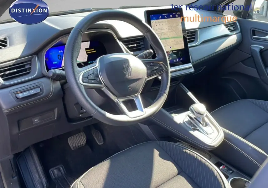 Vue intérieure côté conducteur de la Renault Symbioz noire étoile métal, avec volant cuir et écran tactile central lumineux.