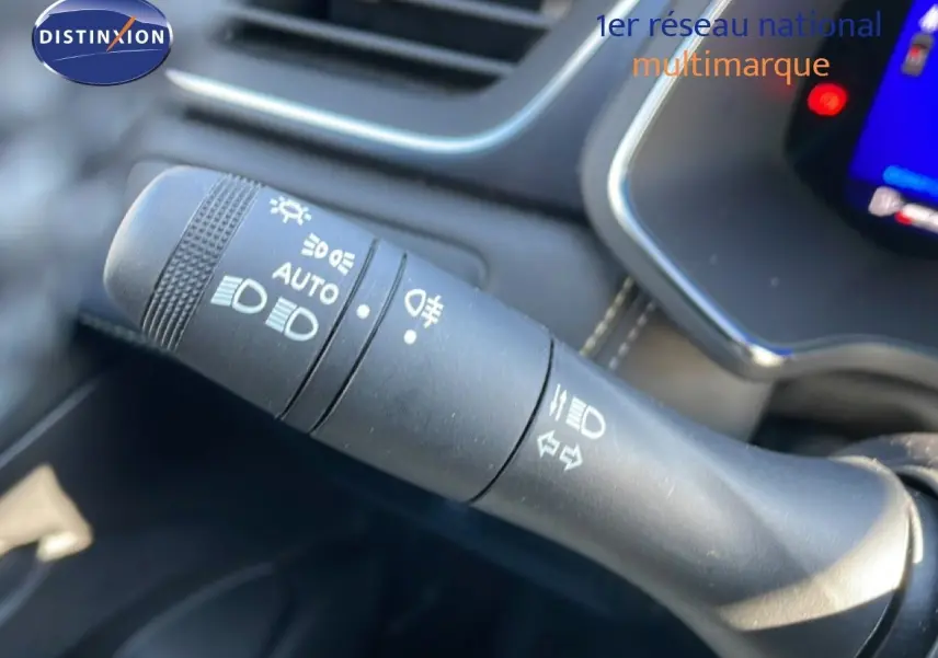 Gros plan sur la commande des phares à gauche du volant dans l’habitacle noir du Renault Symbioz 2025.