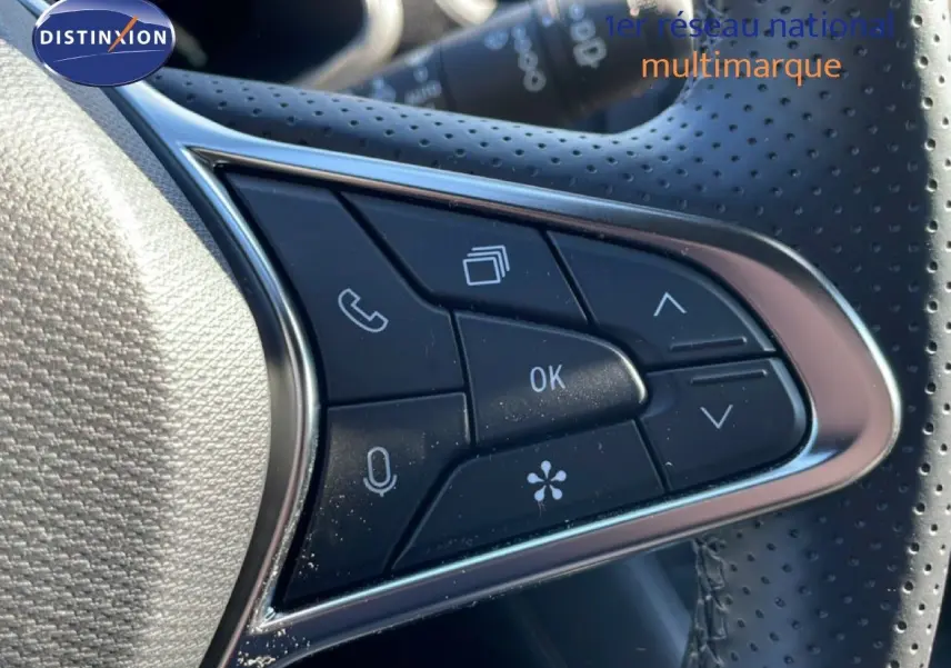 Gros plan sur les commandes multifonctions du volant perforé du Renault Symbioz noir étoile métal 2025.