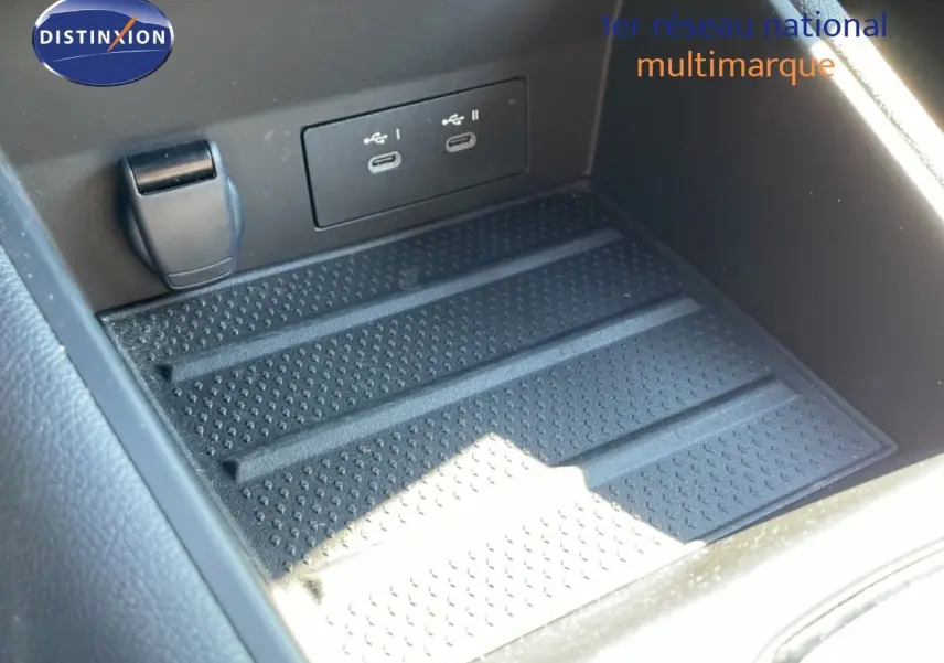 Gros plan sur la console centrale du Renault Symbioz 2025, montrant les ports USB-C et un espace de rangement noir texturé.