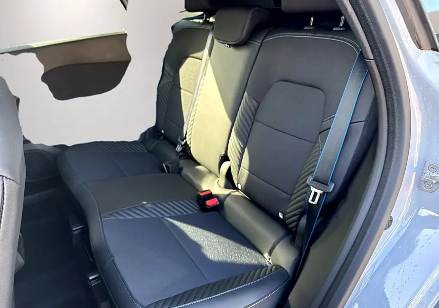 Vue côté droit de la banquette arrière gris foncé avec surpiqûres bleues dans une Renault Symbioz gris rafale.