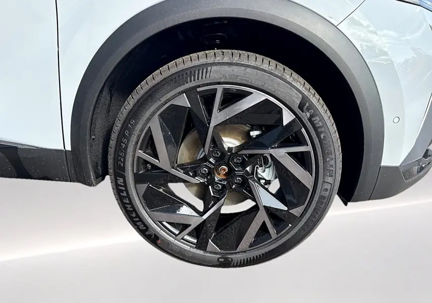 Gros plan sur la roue avant droite de la Renault Symbioz gris rafale avec jante alu noire au design géométrique.
