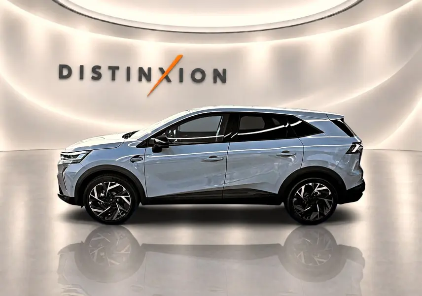 Vue de profil côté gauche du Renault Symbioz gris rafale, avec jantes alu noires et toit blanc dans un showroom lumineux.