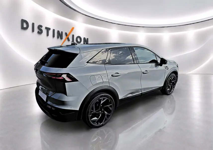 Renault Symbioz gris rafale en 3/4 arrière droit, avec jantes noires et vitres arrière surteintées dans un showroom lumineux.