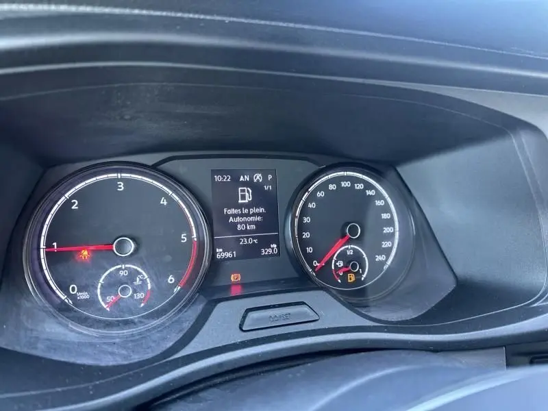 Vue rapprochée du tableau de bord du Volkswagen Transporter blanc 2022, affichant l'autonomie restante et les compteurs.