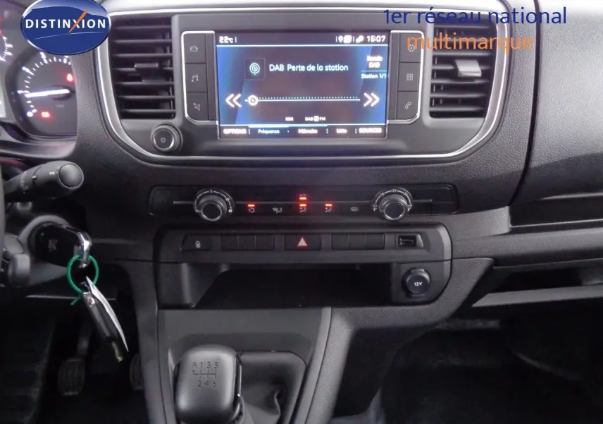Tableau de bord et console centrale du Peugeot Expert Long 2023 en gris, avec écran tactile et levier de vitesses manuel visible.