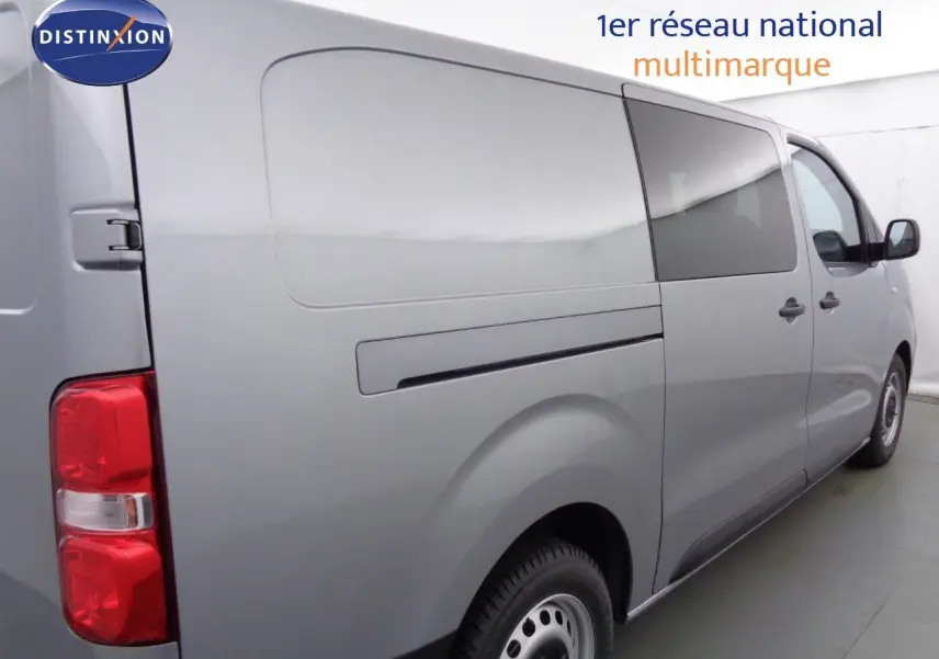 Vue 3/4 arrière droite d'un Peugeot Expert Long gris Artense métallisé avec vitres teintées et portes latérales fermées.