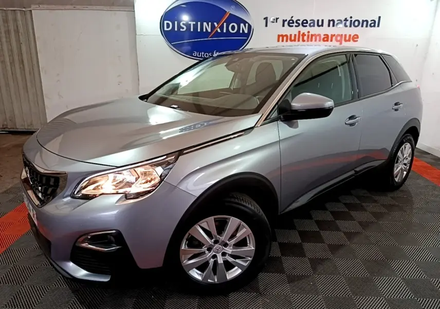 Vue 3/4 avant droit d’un Peugeot 3008 gris clair avec phares allumés dans un showroom.