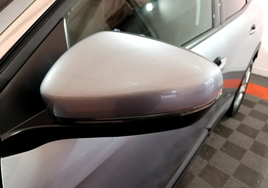 Gros plan sur le rétroviseur droit gris clair du Peugeot 3008 2020, avec portière et jante partiellement visibles.