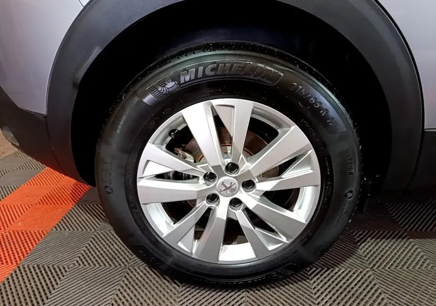 Gros plan sur la roue avant droite du Peugeot 3008 gris clair, avec jante alliage et pneu Michelin visible.