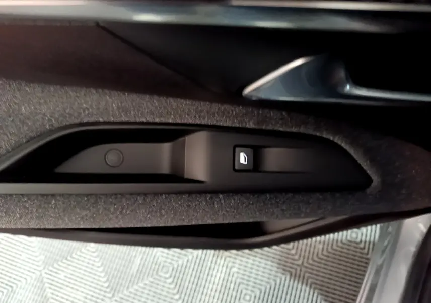 Gros plan sur la commande de verrouillage de porte intégrée à la garniture intérieure côté conducteur du Peugeot 3008 gris clair.