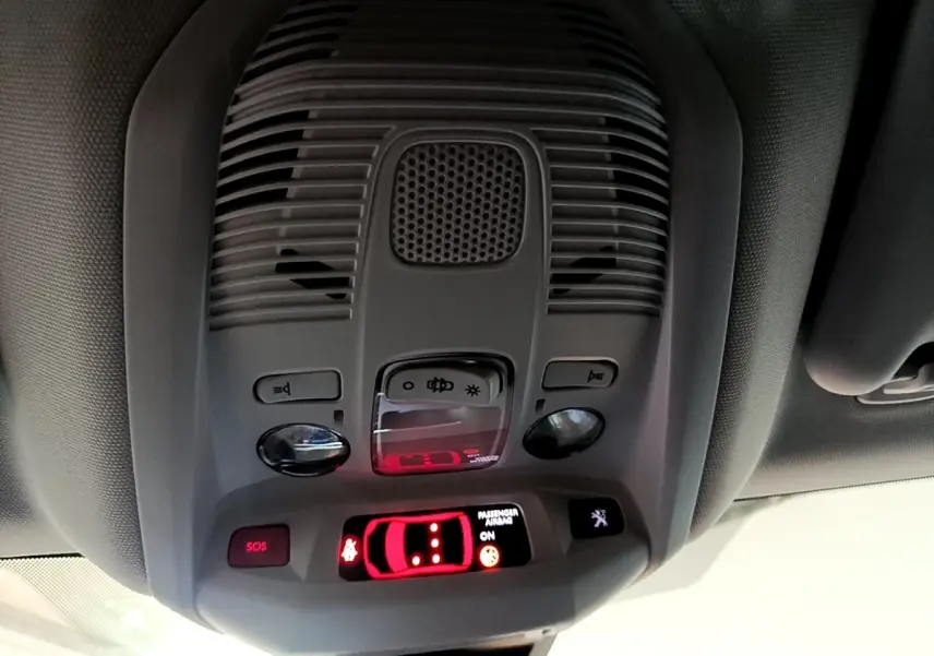 Vue en gros plan du plafonnier gris clair du Peugeot 3008 2020 avec commandes d’éclairage et indicateurs lumineux rouges.