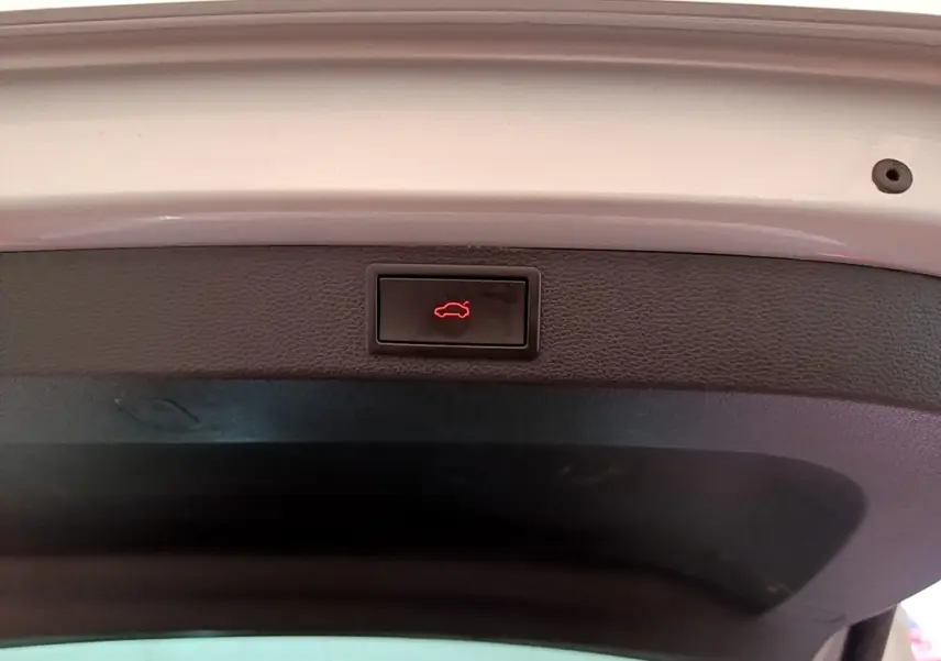 Bouton d'ouverture électrique du coffre sur la face intérieure du hayon d'un Skoda Karoq gris clair 2022.
