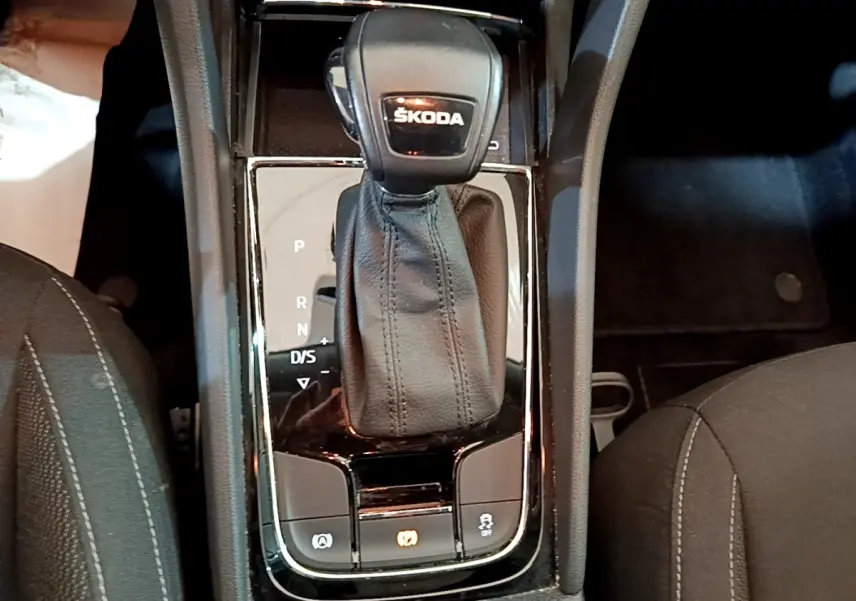 Gros plan sur la console centrale du Skoda Karoq gris clair, mettant en valeur le levier de vitesses automatique DSG7.