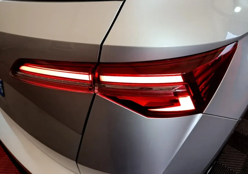 Gros plan sur le feu arrière droit allumé d’un Skoda Karoq gris clair, soulignant ses lignes anguleuses modernes.
