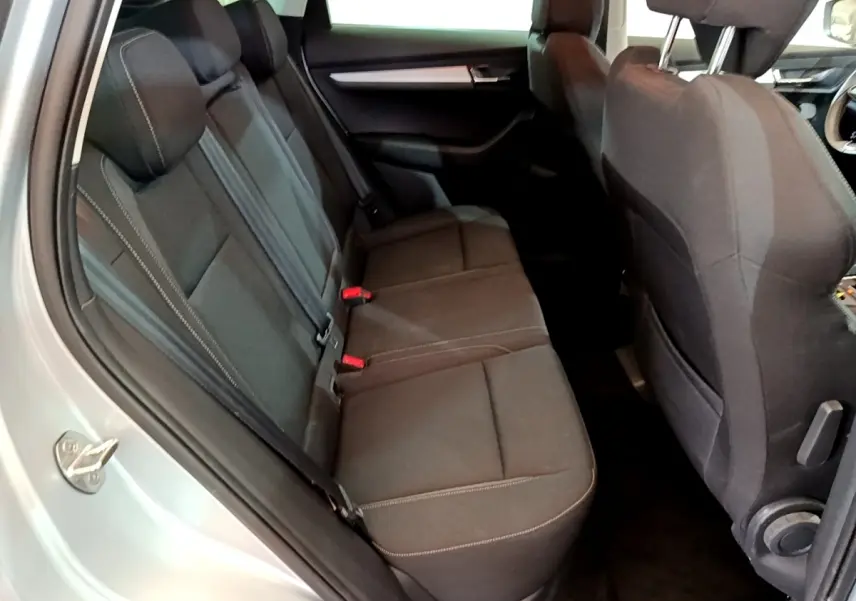 Vue intérieure côté gauche montrant la banquette arrière noire du Skoda Karoq gris clair 2022.
