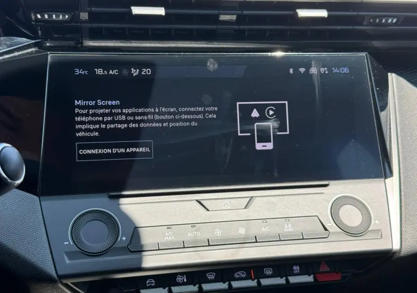 Écran tactile central de la Peugeot e-308 2025 en gros plan avec commandes climatisation et interface Mirror Screen visible.