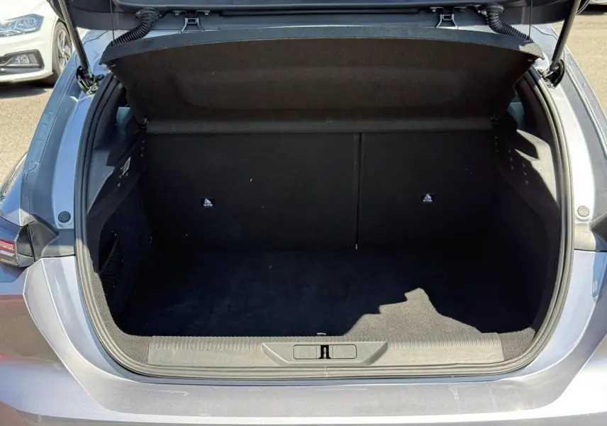 Coffre ouvert vu de l'arrière d'une Peugeot 308 e-308 2025 noir Perla Nera, intérieur noir vide.
