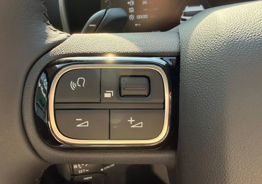 Gros plan sur les commandes vocales et réglages au volant cuir noir du Citroën C5 Aircross Gris Platinium.