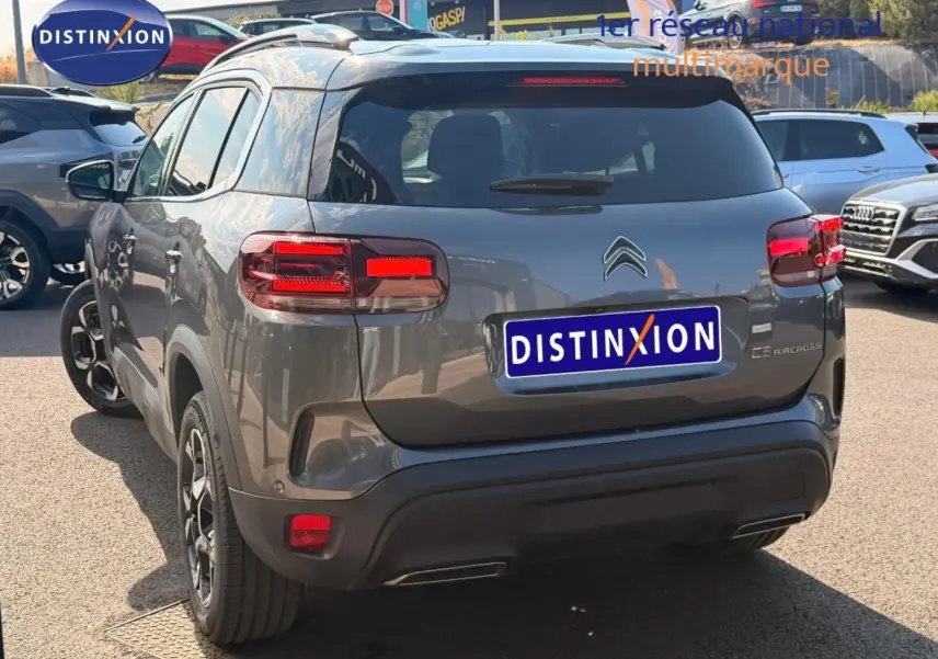 Vue 3/4 arrière d'un Citroën C5 Aircross gris Platinium avec feux arrière LED et jantes alliage noires.