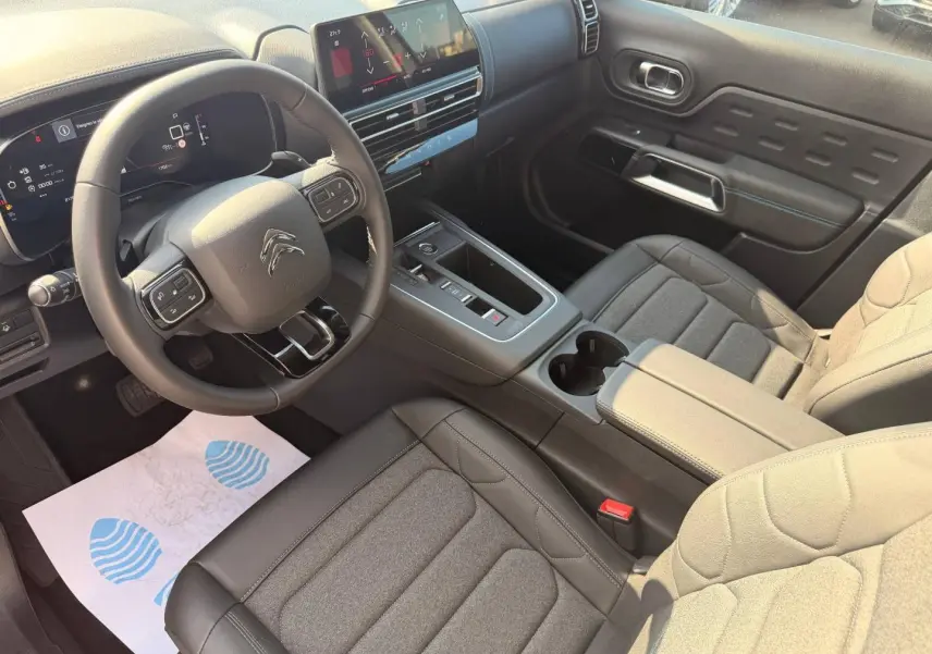 Vue intérieure côté conducteur du Citroën C5 Aircross 2025, volant cuir multifonction et écran tactile central.