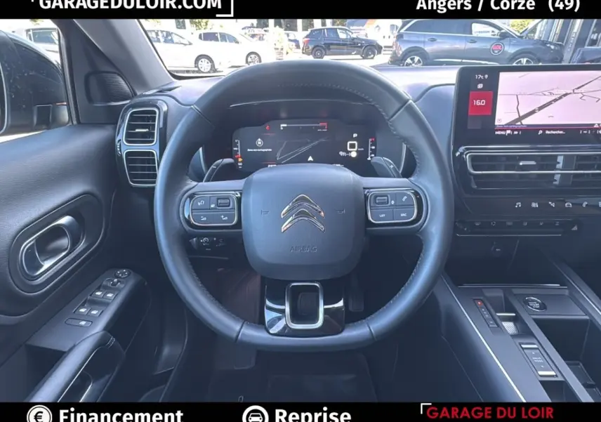 Vue intérieure centrée sur le volant cuir noir et le tableau de bord numérique du Citroën C5 Aircross noir 2025.