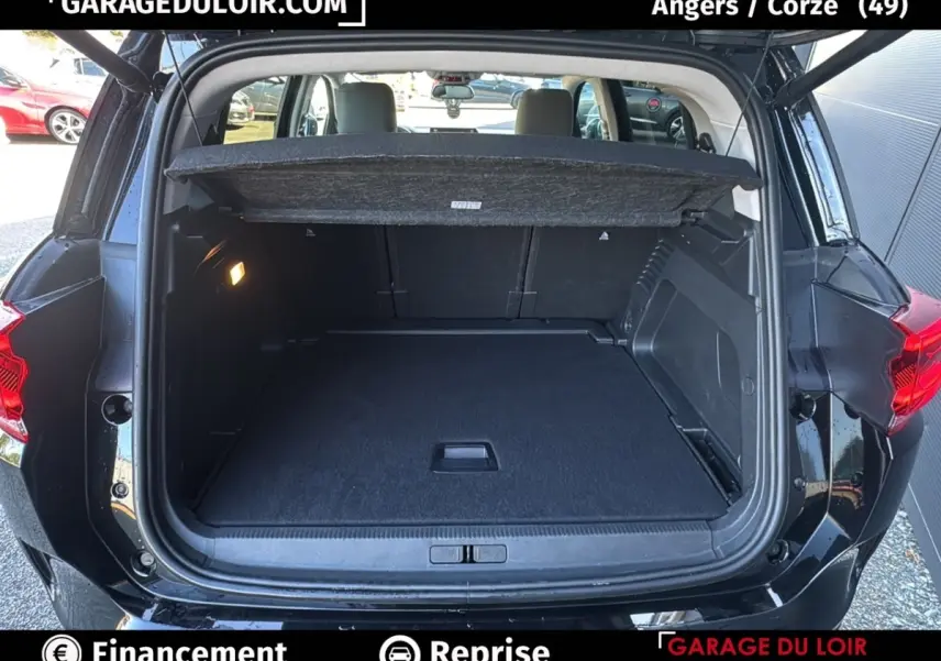 Coffre ouvert noir du Citroën C5 Aircross 2025, vue arrière montrant l'espace de chargement et la tablette de séparation.