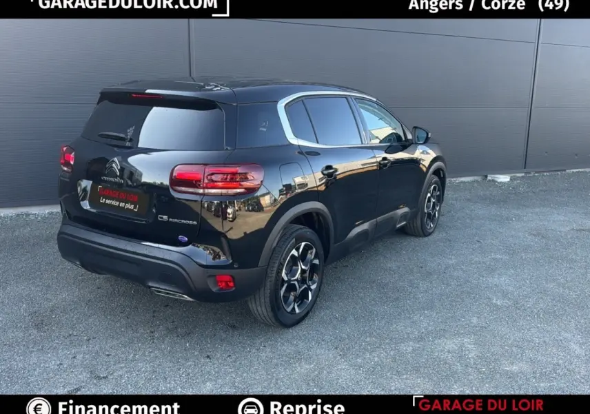 Vue 3/4 arrière droite d'un Citroën C5 Aircross noir 2025 avec jantes distinctives et vitres teintées.
