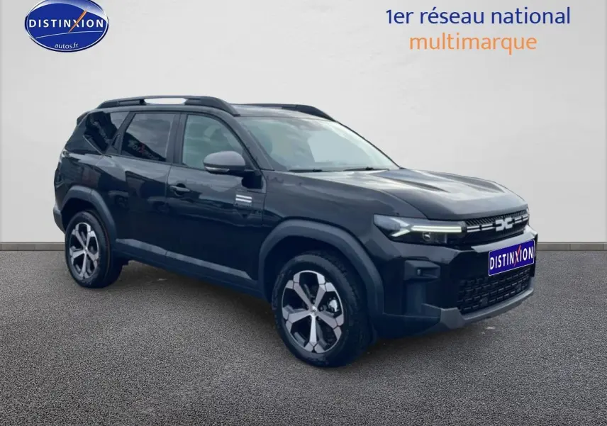 SUV Dacia Bigster noir vu en 3/4 avant droit, avec jantes alliage diamantées et barres de toit visibles.