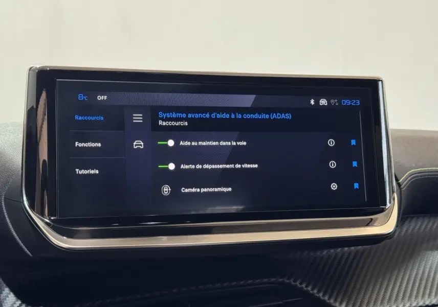 Écran tactile central affichant les aides à la conduite dans l’habitacle d’une Peugeot 208 Hybrid gris clair.
