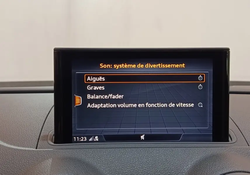 Écran tactile central affichant les réglages audio dans l’habitacle d’une Audi A3 blanche, vue de face.