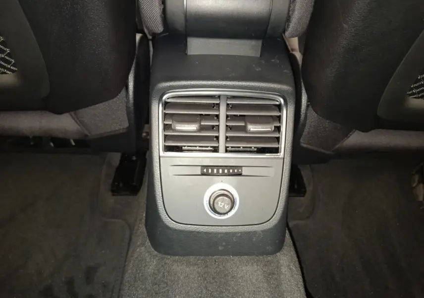 Vue rapprochée de la console centrale arrière noire avec bouches d’aération et prise 12V dans l’Audi A3 blanche 2020.