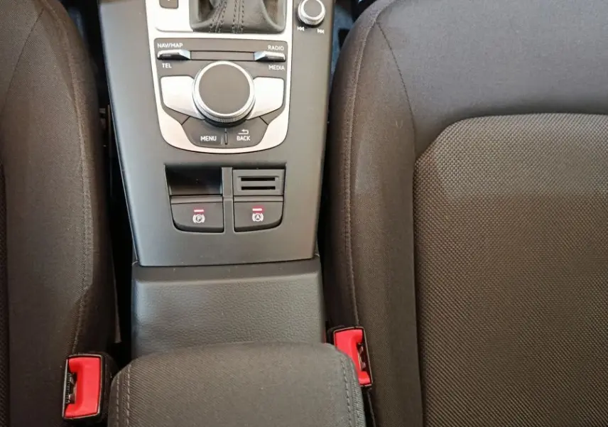 Vue plongeante sur la console centrale noire de l’Audi A3 35 TDI 150 S tronic avec levier de vitesse et accoudoir tissu.