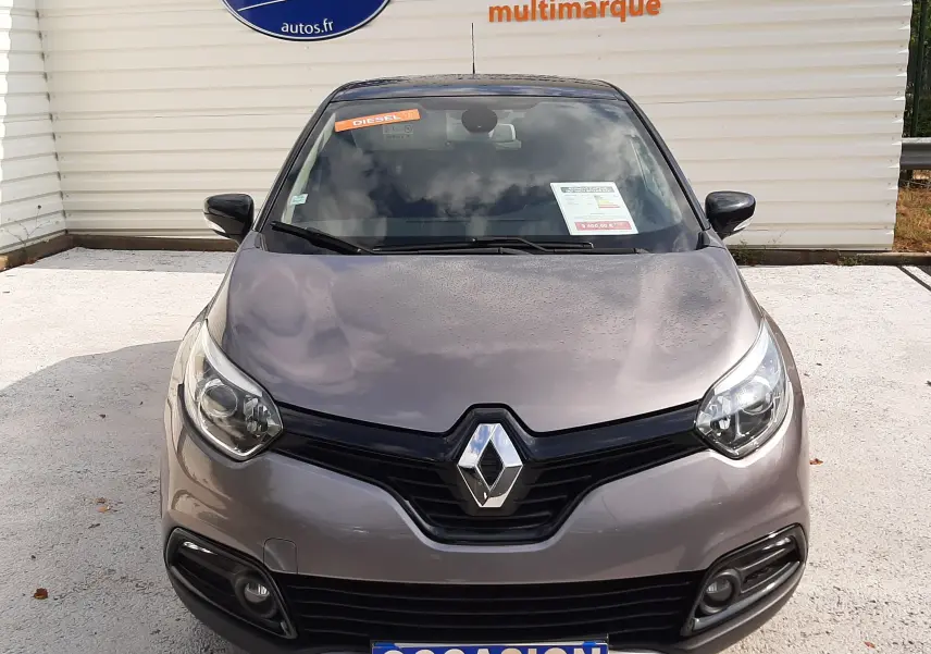 Vue avant d'un Renault Captur gris Cassiopée avec toit noir, affichant une plaque "OCCASION" et un autocollant diesel.