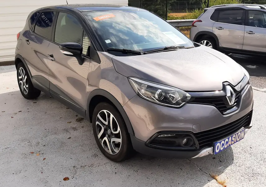 Renault Captur gris cassiopée avec toit noir, vue 3/4 avant droit, jantes alliage et plaque occasion visible.