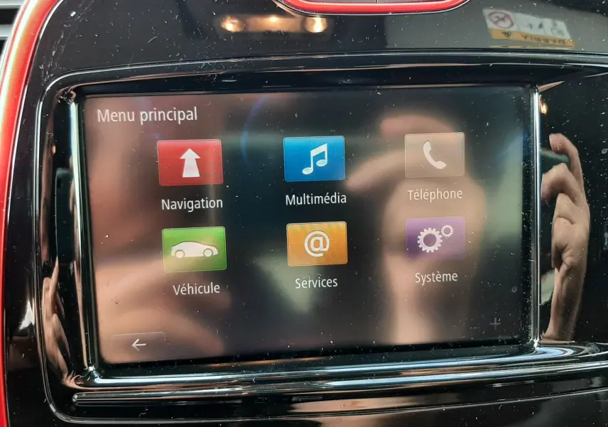 Écran tactile central du tableau de bord Renault Captur 2016, entouré de cadre noir et rouge, affichant le menu principal.