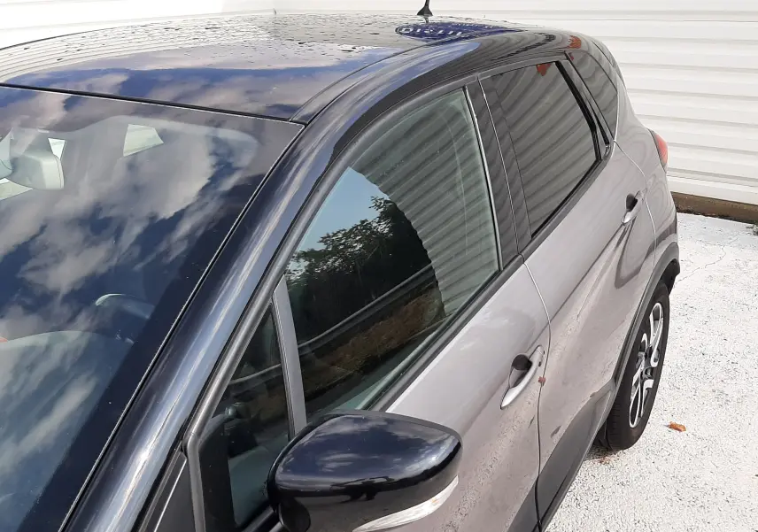 Vue 3/4 arrière côté gauche du Renault Captur gris Cassiopée avec toit noir et rétroviseur noir brillant.