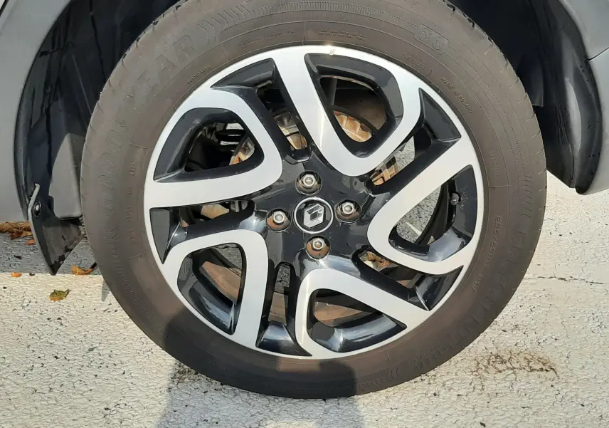 Gros plan sur la roue avant droite du Renault Captur gris Cassiopée avec jante alliage bicolore noire et argent.