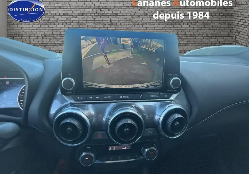 Vue intérieure centrée sur l’écran tactile affichant la caméra de recul du Nissan Juke blanc 2024.