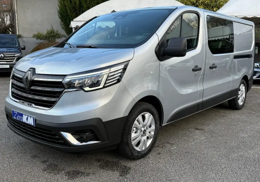 Vue 3/4 avant droit d'un Renault Trafic cabine approfondie gris Highland avec calandre noire et phares LED modernes.
