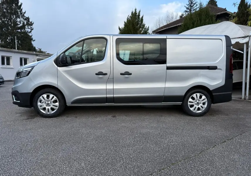 Vue frontale d'un Renault Trafic cabine approfondie gris Highland 2025 avec calandre noire et logo Renault bien visible.