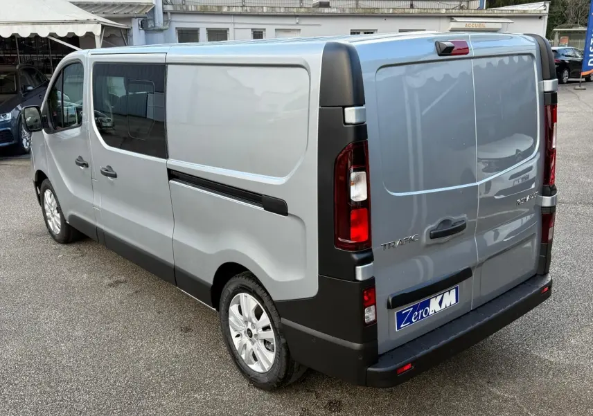 Vue 3/4 avant droit d’un Renault Trafic cabine approfondie gris Highland avec jantes alliage et calandre noire.