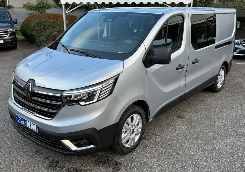 Vue intérieure côté conducteur du Renault Trafic cabine approfondie 2025, sièges gris et volant noir visibles.